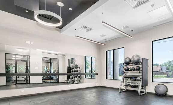 A spacious room with a grey floor and a large window on the right side.