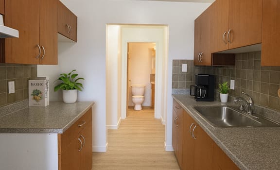 A kitchen with brown cabinets and a white refrigerator.
