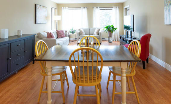 A dining room with a wooden table and chairs.