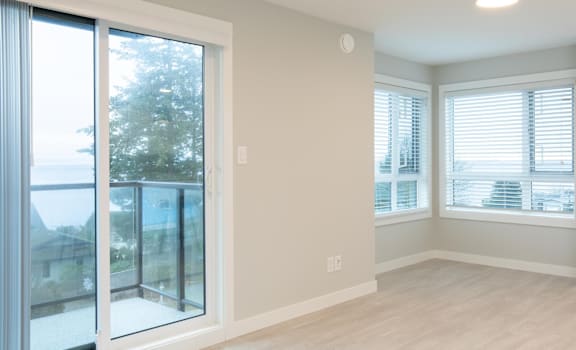 A room with a sliding glass door and a window with blinds.