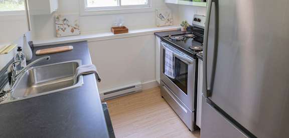 A modern kitchen with a stainless steel refrigerator and oven.