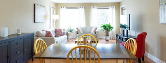 A modern dining room with a wooden table and chairs.