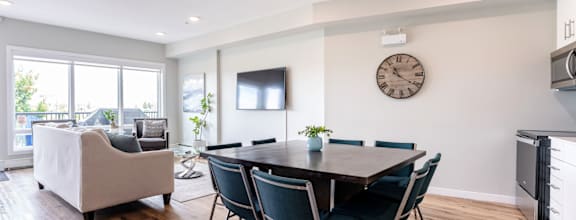A modern dining room with a wooden table and chairs.