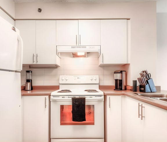 A modern kitchen with a stainless steel refrigerator and wooden flooring.