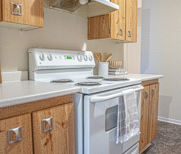 A modern kitchen with a stainless steel refrigerator and wooden flooring.