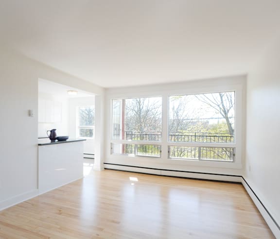 A modern kitchen with a stainless steel refrigerator and wooden flooring.