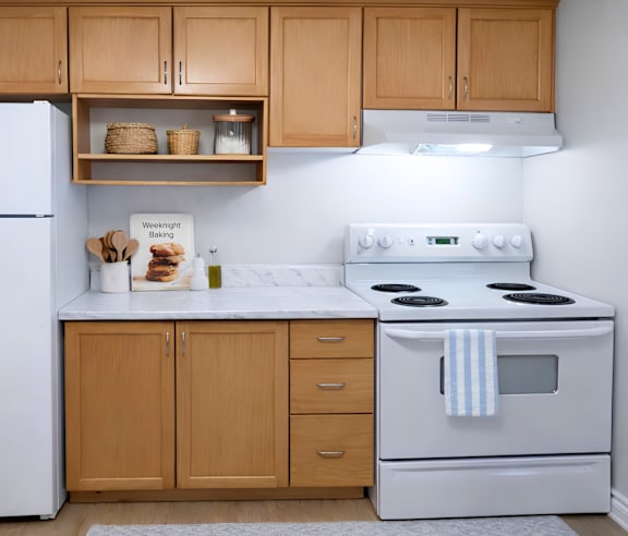 A modern kitchen with a stainless steel refrigerator and wooden flooring.