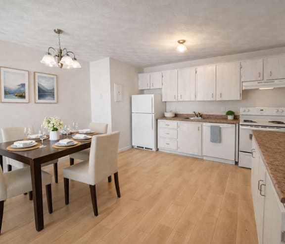 A modern kitchen with a stainless steel refrigerator and wooden flooring.