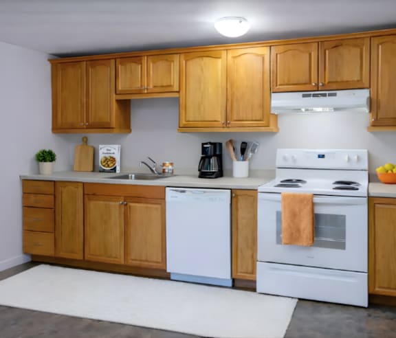 A modern kitchen with a stainless steel refrigerator and wooden flooring.