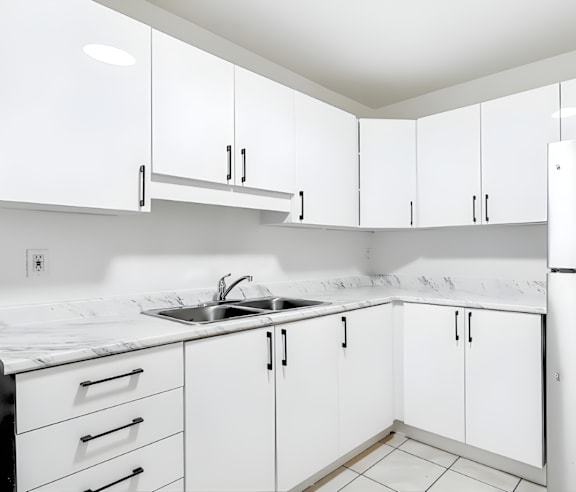 A modern kitchen with a stainless steel refrigerator and wooden flooring.