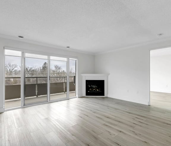 A modern kitchen with a stainless steel refrigerator and wooden flooring.