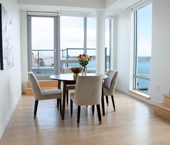 A modern kitchen with a stainless steel refrigerator and wooden flooring.