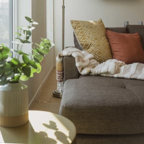 a living room with a couch and a vase with a plant  at The Freelon at Sugar Hill, Detroit, MI 48201