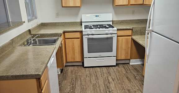 A modern kitchen with wooden cabinets and a stainless steel countertop.