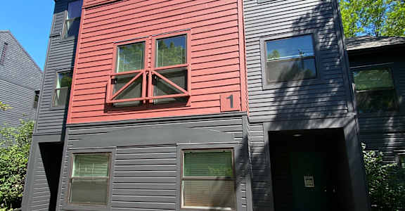 the front of a house with a red and black facade