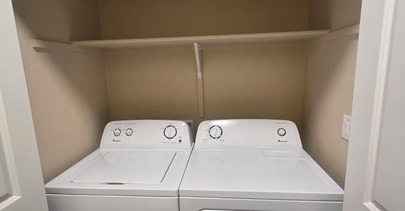 A white washing machine and dryer in a small laundry room.