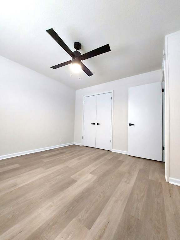 an empty living room with white walls and a ceiling fan