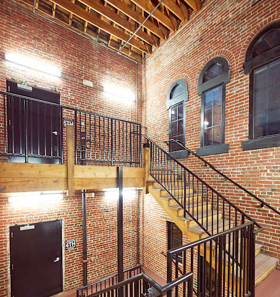 A staircase with a black railing and wooden steps.