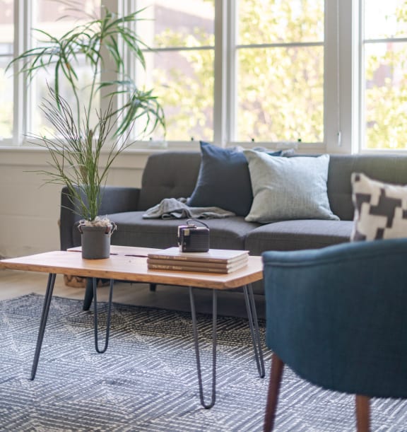 a living room with a brick wall and a navy couch