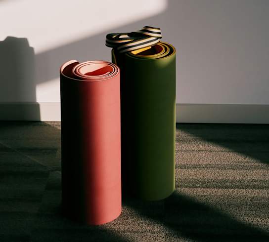 Two cylindrical objects with metallic caps are placed on a carpeted floor.