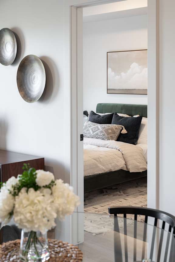 A grey couch with pillows and a blanket is on a patio.