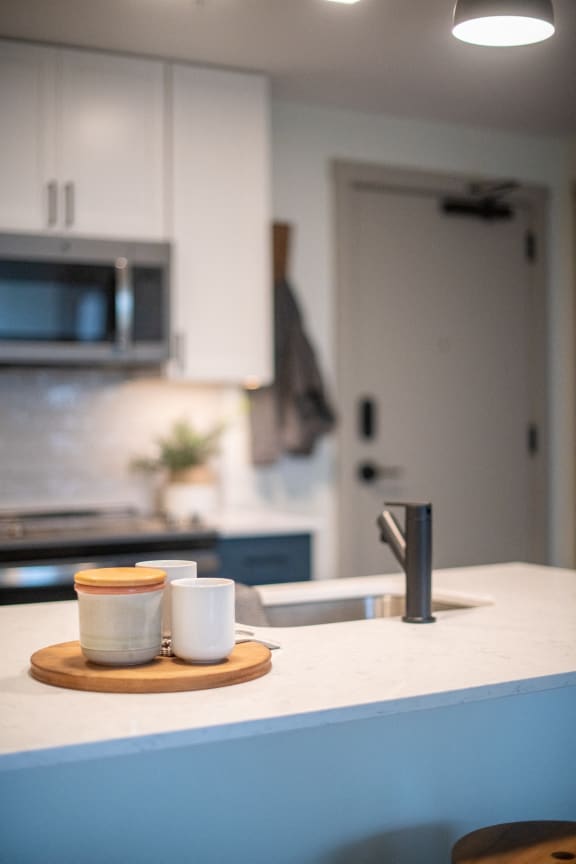 a kitchen counter with two cups and a sink