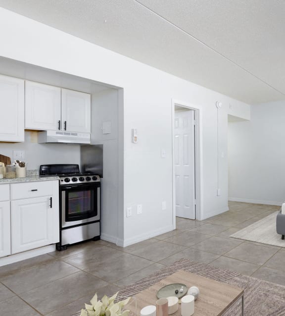 a bedroom with a bed and a kitchen and a living room