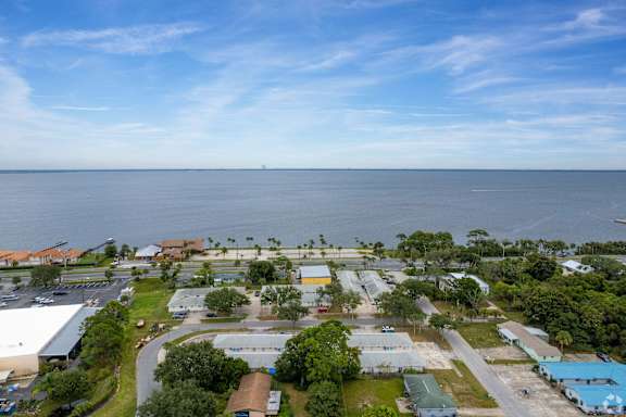an aerial view of a neighborhood with the ocean in the background