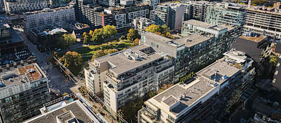 A large building complex with a green space in the middle.