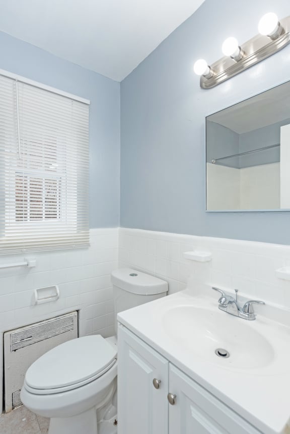 a bathroom with a toilet sink and mirror