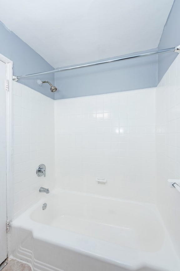 a bathroom with a white bathtub and a blue ceiling
