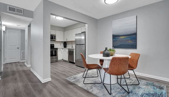 a dining area with a table and chairs and a kitchen in the background at Enclave at Breckenridge Apartments, Louisville, KY
