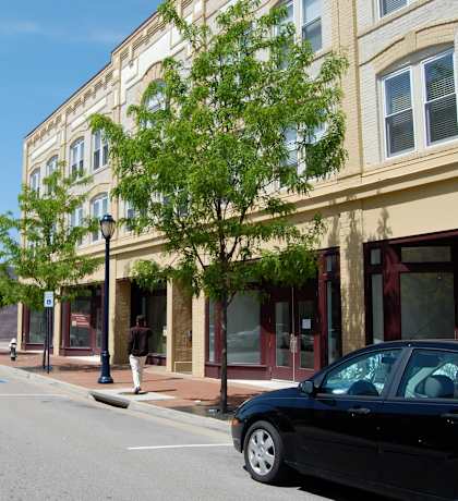 A black car is parked on the side of a street.