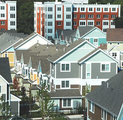 a group of houses in front of an apartment building