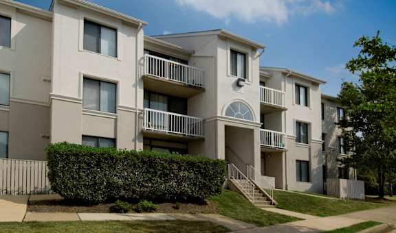 Apartment building with a green hedge in front.