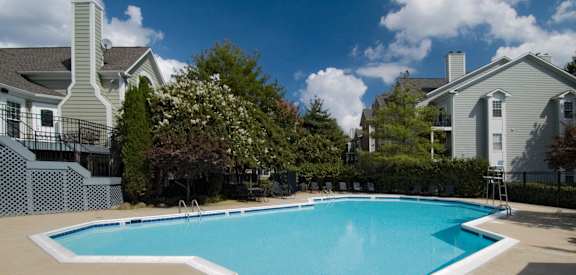 A swimming pool surrounded by residential houses.
