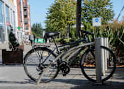 Thumbnail 2 of 8 - a bike chained to a bike rack on a sidewalk