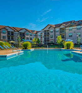a swimming pool with an apartment building in the background