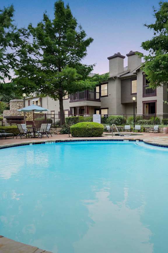 a swimming pool with an apartment building in the background
