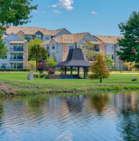 an apartment building overlooking a lake with a gazebo