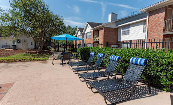 A row of blue and white striped chairs are arranged on a patio.