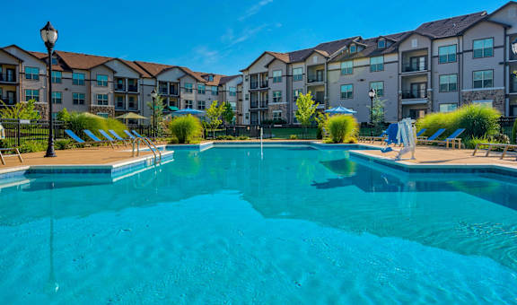 a swimming pool with an apartment building in the background