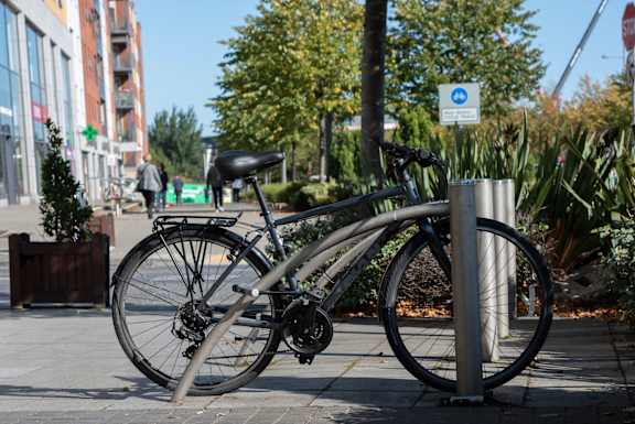 a bike chained to a bike rack on a sidewalk