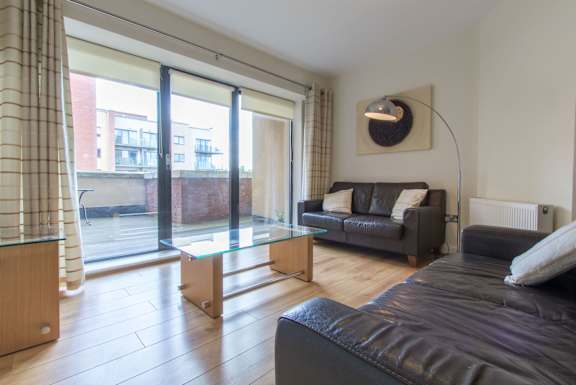 a living room with leather furniture and a glass table