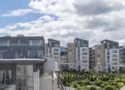 Thumbnail 3 of 5 - a group of buildings with a cloudy sky in the background