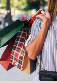 a woman holding a bunch of shopping bags and ties at Madison Gateway, St. Petersburg, FL