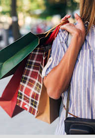 A woman is holding shopping bags in her hands.