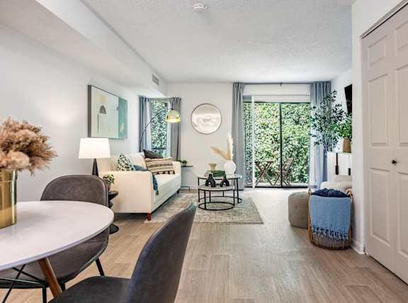 a living room with white walls and a sliding glass door