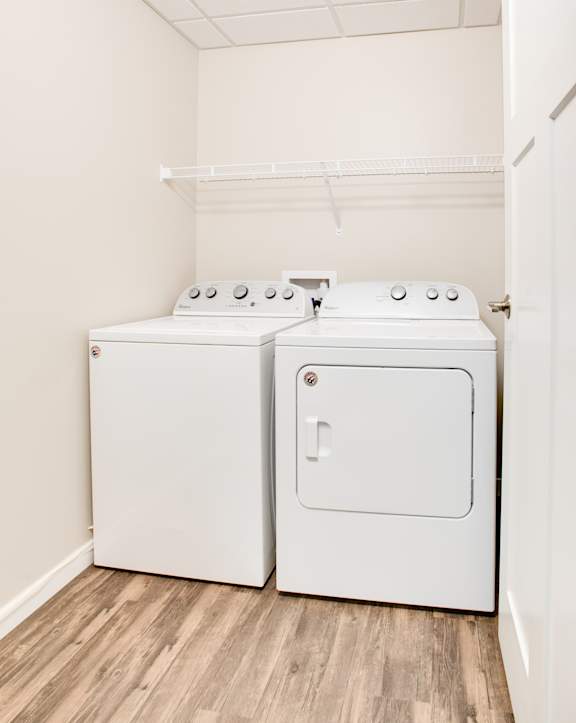 A small laundry room with a washer and dryer. at Beacon Estates Apartments, North Dakota