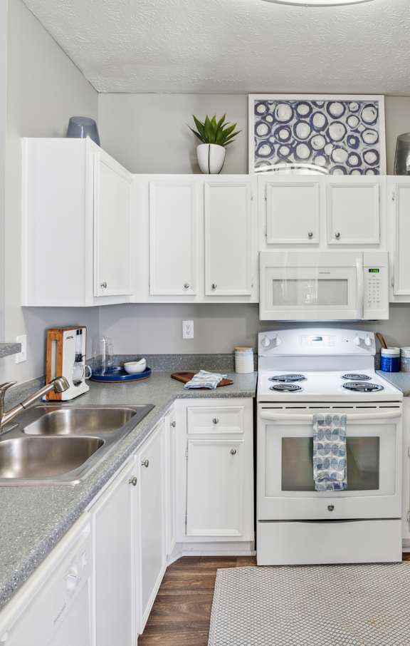 A kitchen with white appliances and cabinets.at The Atlantic Canton Ridge, Georgia, 30114
